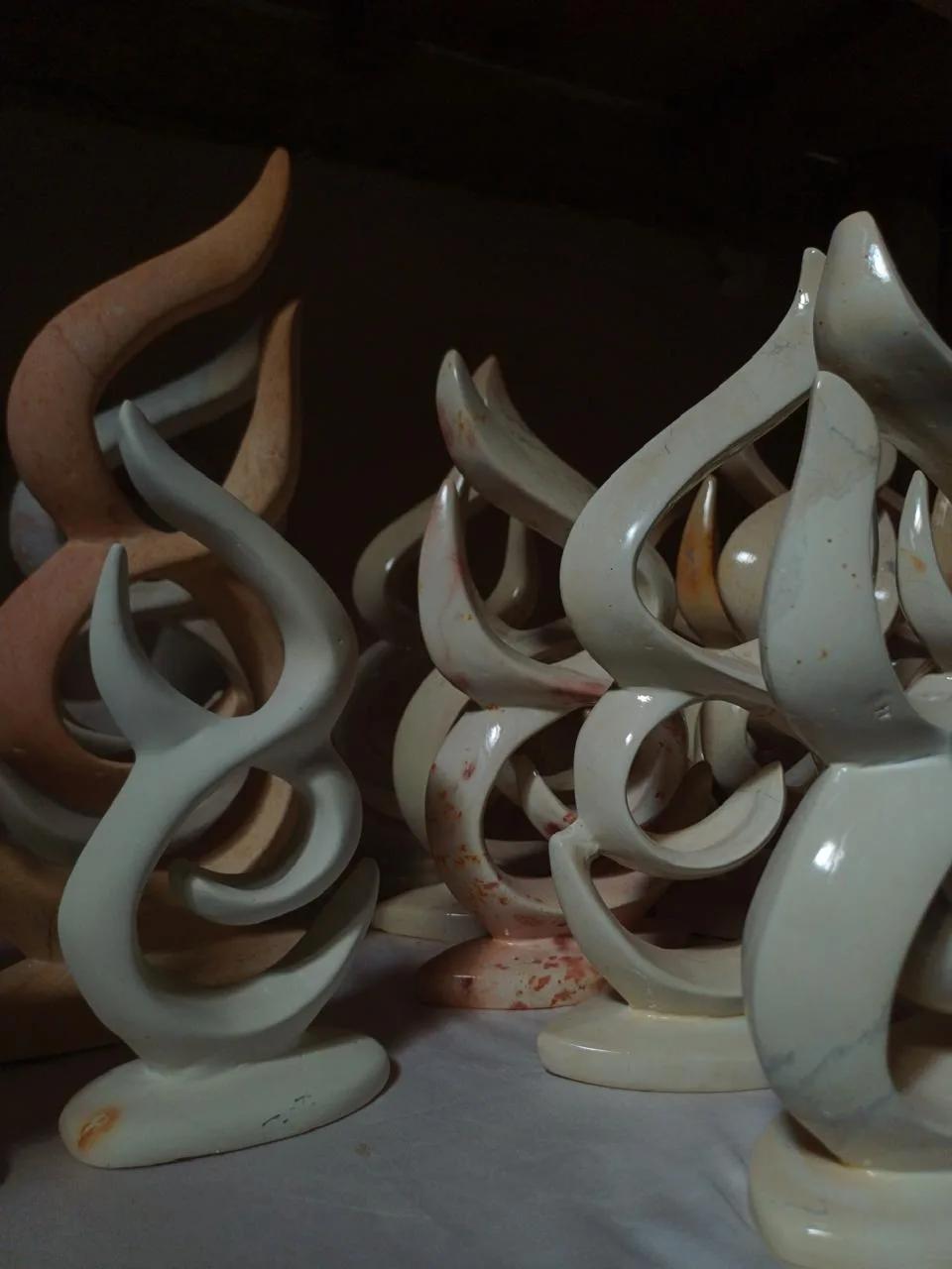 Polished soapstone sculptures shaped like flames, in white, cream and pink stone